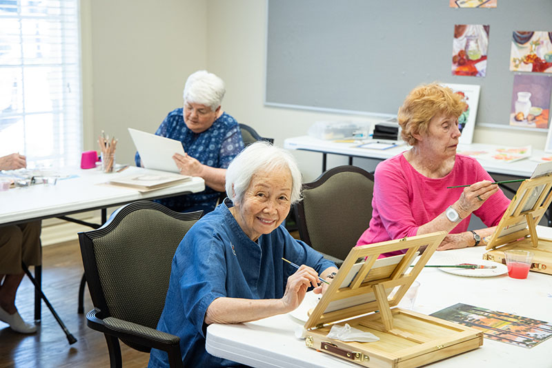 Senior residents painting in a art class.